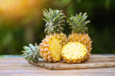 Yiyecek için ananas dilimi tahta kesme tahtası, doğal arka planda olgun ananas, taze ananas tropikal meyveler yaz mevsimi.