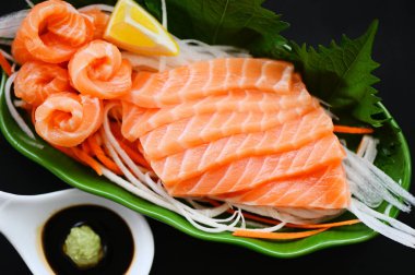 somon balıklı somon balığı fileto Japon menüsünde shiso perilla yaprağı, limon ve baharat, deniz mahsulleri için taze çiğ somon balığı soslu ve wasabi soslu. 