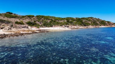 Etrafı resiflerle çevrili küçük tropikal adanın havadan görünüşü. Queensland, Townsville yakınlarındaki Acheron Adası. 