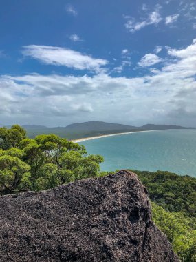 Nefes kesen bir kıyı manzarası, çarpıcı kaya çıkıntıları, kumlu plajlar ve çevrenin canlı yeşillikleri.
