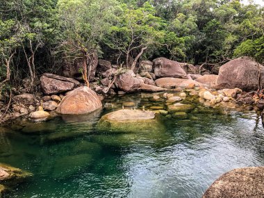 Kayaların ve yeşilliklerin arasına kurulmuş sakin bir havuz. Rahatlamak ve doğayı keşfetmek için mükemmel.