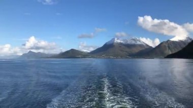 Sersemletici dağlar, berrak mavi gökyüzünün altındaki sakin ve sakin sularda güzel bir şekilde yansıtılır.
