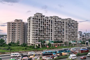 Pune, Maharashtra, Hindistan-24 Eylül 2022: Hızlı büyüyen şehirde yüksek binalar toplumunun önünde trafik akışı.