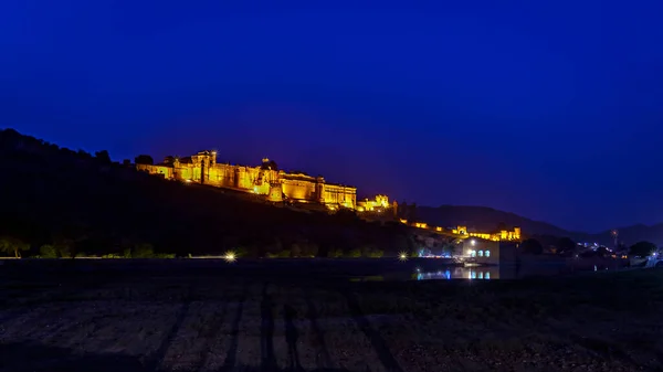 Jaipur, Rajasthan, Hindistan 'daki Amer Kalesi' nin mavi gökyüzü arka planıyla gece aydınlandı
