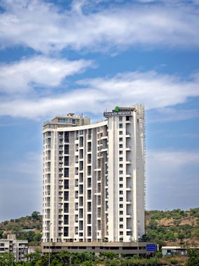 Pune, Maharashtra, Hindistan-1 Mayıs 2023: Arka planda güzel, tüylü, mavi bulutlu gökyüzü olan uzun şehir binası.
