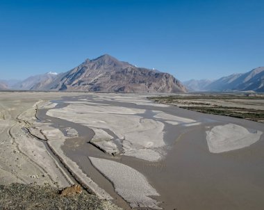 Dağlar, akan Shyok nehri mavi gökyüzü arka planıyla Nubra Vadisi 'ndeki Diskit' e gidiyor, Leh..