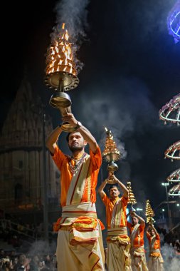 Varanasi, Uttar Pradesh, Hindistan - 21 Mart 2024: Rahipler, Hindistan 'ın yaşayan en eski şehirlerinden biri olan Varanasi' de Ganj nehrinin kıyısında Ganga aarti 'yi icra ediyorlar..