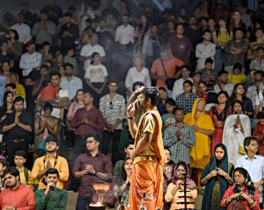 Varanasi, Uttar Pradesh, Hindistan - 22 Mart 2024: Hindistan 'ın yaşayan en eski şehirlerinden biri olan Hindistan' ın ruhani başkenti Varanasi 'de Ganj nehrinin kıyısında Ganga aarti' yi seslendiren rahip.