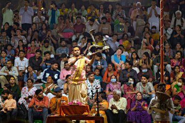 Varanasi, Uttar Pradesh, Hindistan - 22 Mart 2024: Hindistan 'ın yaşayan en eski şehirlerinden biri olan Hindistan' ın ruhani başkenti Varanasi 'de Ganj nehrinin kıyısında Ganga aarti' yi seslendiren rahip.