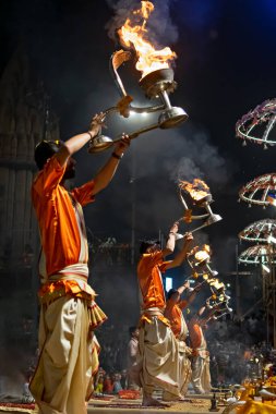 Ağır gümüş bir lambayla rahipler, Hindistan 'ın yaşayan en eski şehirlerinden biri olan Varanasi' de Ganj nehrinin kıyısında Ganga aarti 'yi icra ediyorlar..