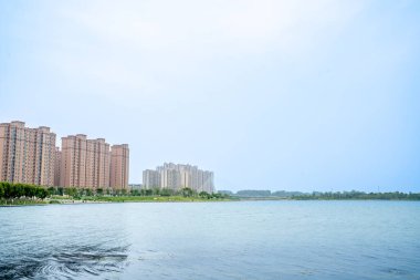 Mavi gökyüzünün altında şehir ve göl