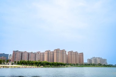 Mavi gökyüzünün altında şehir ve göl