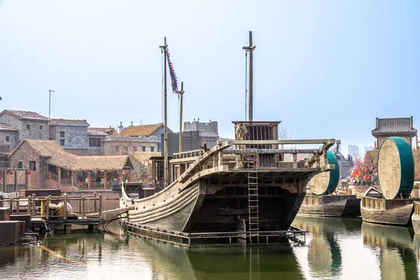 stock image This is a photo showcasing the ancient boat and waterfront scenery in Kaifeng Great Song Wuxia City, reflecting the blend of tradition and history.