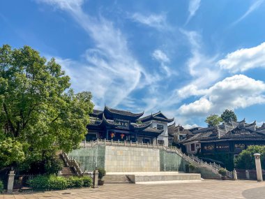 Zhangjiajie 'deki kaya sütunlarını ve dağları sis kaplıyor, vadide güneş ışığı var.