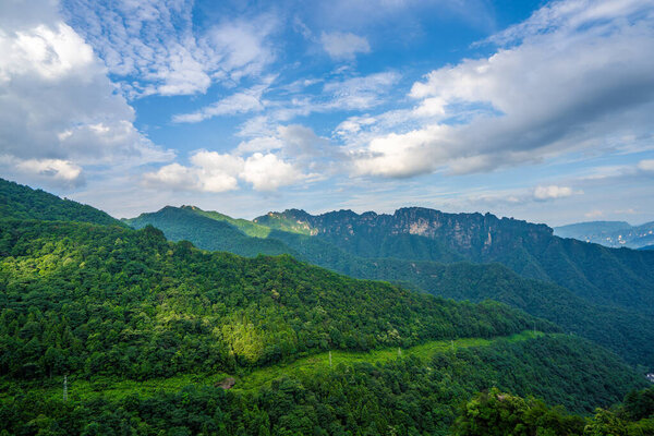 Mist covers the rock pillars and mountains in Zhangjiajie, with sunlight in the valley