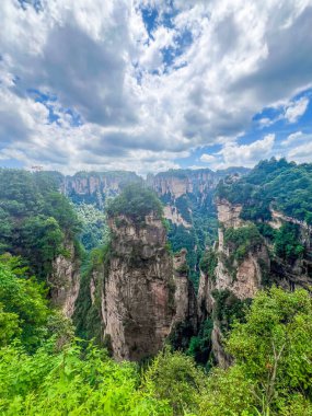 Çin 'in Hunan kentindeki Zhangjiajie manzarasında eşsiz dağ zirveleri ve yemyeşil ormanlar yer alıyor.