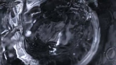 Super Slow Motion Makro Şat Ice Cube 'un Karanlık Arkaplanda Votka ile 1000 fps' te Cama Düşüşü. 4K Çözünürlükte Yüksek Hız Sinema Kamerası ile Çekim.