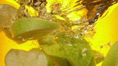 Yeşil Elma Dilimlerinin Süper Yavaş Çekimi Juice Girdabına 1000 fps hızla düşüyor. 4K 'da yüksek hızlı sinema kamerasıyla çekildi..