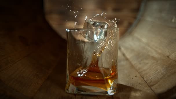 Super Slow Motion Shot Ice Cube Falling Glass Whiskey Wooden — Stock Video