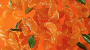 Peeled Mangerines ve Green Leaves 'in Süper Yavaş Çekimi. 1000fps hızla Kameraya doğru uçuyor. 4K 'da Yüksek Hız Sinema Kamerası ile çekildi..