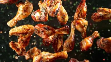 Izgara Baharatlı Tavuk Kanatları ve Davul Çubukları 'nın Süper Yavaş Çekimi 300 metre yükseklikte kameraya doğru uçuyor. 4K 'da yüksek hızlı sinema kamerası ile çekildi...