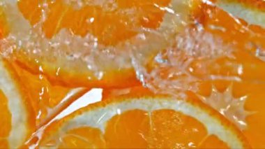 Turuncu Dilimlere Sıçrayan Suyun Süper Yavaş Çekimi. 4K 'de Yüksek Hız Sinema Kamerası ile çekildi..