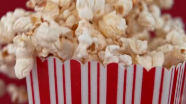 Kırmızı arka planda patlamış mısırı yavaş çekimde düşürmek. 1000Fps 4K 'de yüksek hızlı sinema kamerasıyla çekildi..