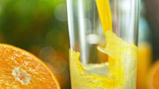 新鮮なオレンジジュースの超スローモーションショットは1000Fpsでガラスに入れられています 4Kで高速シネマカメラで撮影 — ストック動画