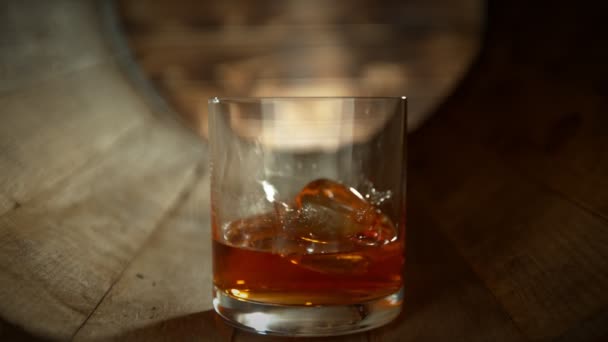 Super Slow Motion Shot Ice Cube Falling Glass Whiskey Wooden — Vídeo de stock