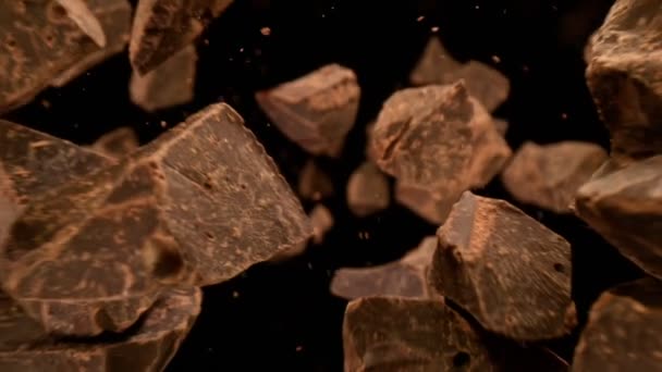 Super Slow Motion Shot Falling Raw Chocolate Chunks Zwarte Achtergrond — Stockvideo
