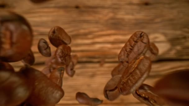 咖啡豆在木料背景上以1000Fps的速度坠落的超级慢动作细节镜头 以4K高速电影摄影机拍摄 — 图库视频影像