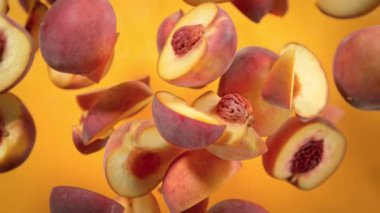 Şeftali Kesiklerinin Süper Yavaş Çekimi Turuncu Arkaplanda Kameraya doğru 1000 fps hızla uçuyor. 4K 'da Yüksek Hız Sinema Kamerası ile çekildi.