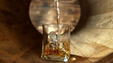 Süper Yavaş Çekim Viski Bardağa Doldurulurken Tahta Fıçı 'nın içinde 300 metre yükseklikte buz küpleriyle. 4K 'da Yüksek Hız Sinema Kamerası ile çekildi..