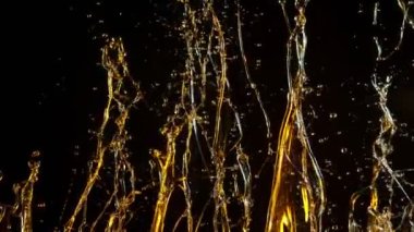 Kara Arkaplanda Altın Yağ Sıçratma 'nın Süper Yavaş Çekimi, 1000fps' te. 4K 'da yüksek hızlı sinema kamerası ile çekildi...