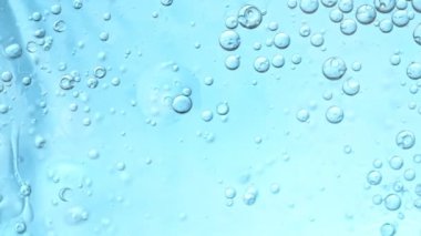 Yağ Baloncuklarının Süper Yavaş Çekimi Açık Mavi Gradyan Arkaplan 'da Suda Hareket Ediyor. 4K 'da Yüksek Hız Sinema Kamerası ile çekildi..