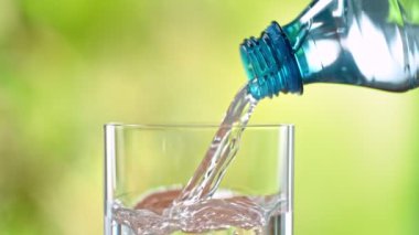 Super Slow Motion Detail Shot of Pouring Pure Water into Glass on Green Background at 1000fps. Filmed with High Speed Cinema Camera in 4k.