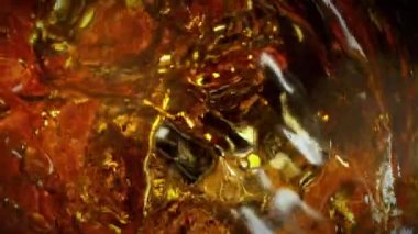 Super Slow Motion Detail Shot of Waving Golden Alcohol Liquid in Glass Bottle at 1000fps. Filmed with High Speed Cinema Camera at 4K.