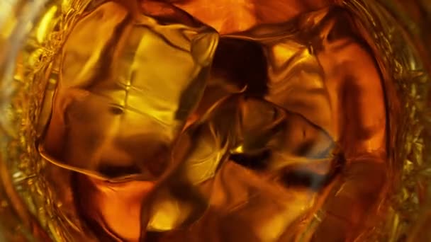 超スローモーション詳細1000 Fpsでガラスの中で振動する黄金のアルコール液体と氷のキューブのショット 4Kで高速シネマカメラで撮影 — ストック動画