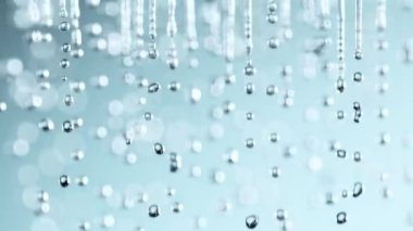 Super Slow Motion Shot of Various Water Drops Falling on Light Blue Background at 1000fps. Filmed with High Speed Cinema Camera at 4K.