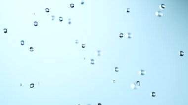 Super Slow Motion Shot of Various Water Drops Falling on Light Blue Background at 1000fps. Filmed with High Speed Cinema Camera at 4K.