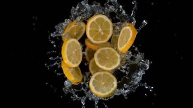 Süper yavaş çekim, patlamış limon dilimlerini, siyaha vuran suyla birlikte 180 metrede döndürmek. Yüksek hızlı sinema kamerasıyla çekilmiş..