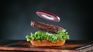 Hamburgerin Düşen ve Yığılan Parçalarının Süper Yavaş Çekimi. 4K 'da Yüksek Hız Sinema Kamerası ile çekildi..