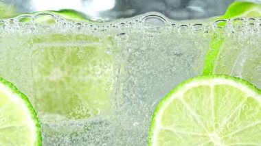 Limonata ve limon dilimleri ile buzlu limonata içerken 1000 fps 'de Süper Yavaş Çekim. 4K 'da Yüksek Hız Sinema Kamerası ile çekildi..