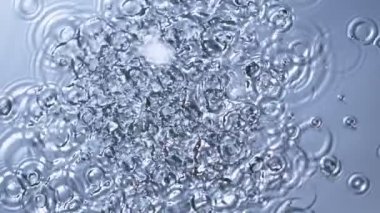 Super Slow Motion Top Shot of Water Drops Falling into Water Surface at 1000fps. Filmed with High Speed Cinema Camera in 4K Resolution.