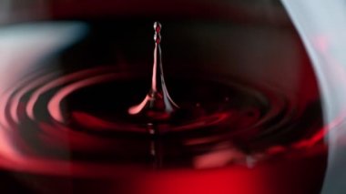 Super Slow Motion Macro Shot of Wine Drop Falling into Red Wine in Glass at 1000fps. Filmed on High Speed Cinema Camera in 4K.