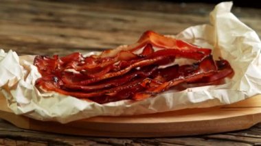 Super Slow Motion Shot of Roasted Bacon Slices Falling on Crumplet Paper at 1000 fps. Filmed with High Speed Cinema Camera in 4K Resolution.