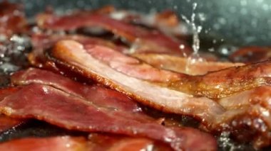 Super Slow Motion Shot of Roasted Bacon Slices Falling into Pan at 1000 fps. Filmed with High Speed Cinema Camera in 4K Resolution.