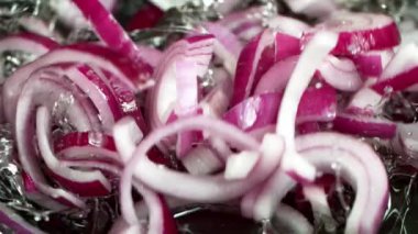 Super Slow Motion Shot of Falling Red Onion Cuts into Oil in Pan at 1000 fps. Filmed with High Speed Cinema Camera in 4K Resolution.