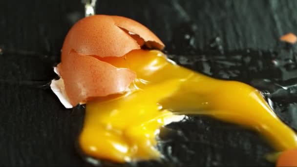 Super Slow Motion Shot Falling Breaking Whole Egg Black Table — Vídeo de Stock