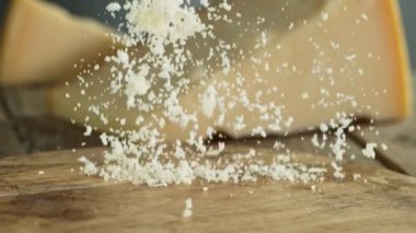 Super Slow Motion Shot of Grated Parmesan Falling on Wooden Board at 1000 fps. Filmed with High Speed Cinema Camera at 4K.